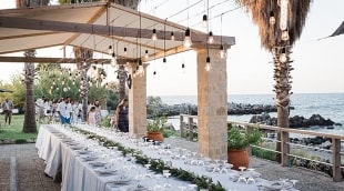 Vestuvinis stalas vilos kiemelyje su vaizdu į jūrą